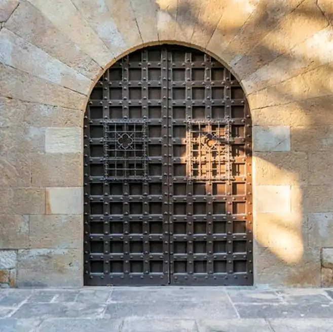Puertas de portal Miguel A. del Barrio: puerta de hierro con arco de piedra y herrajes reforzados